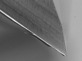 Hauptschneide eines HSS Fräsers vor dem Beschichten: (a) ausgeprägte Grate im Anlieferungszustand;